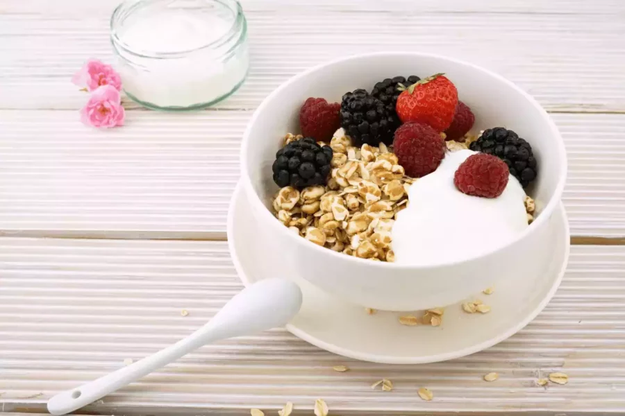 yoğurt üzerine eklenmiş orman meyveleri ve müsli