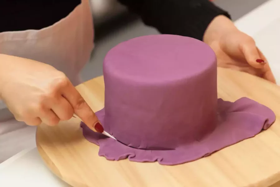 pastanın üstünü şeker hamuruyla kaplayan biri