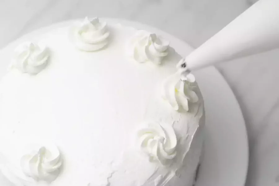 krem şanti ile süslenen beyaz sade pasta