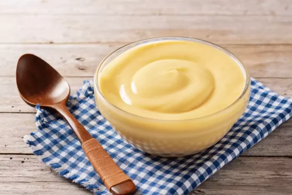 mavi kareli bez üzerinde bir kase pasta kreması