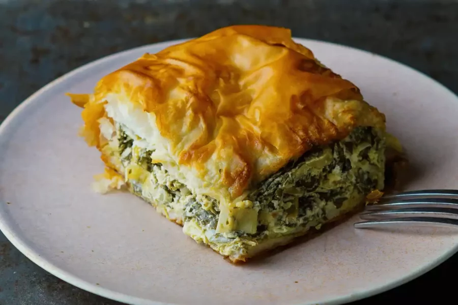 tabakta 1 kare dilim kesilmiş ıspanaklı börek