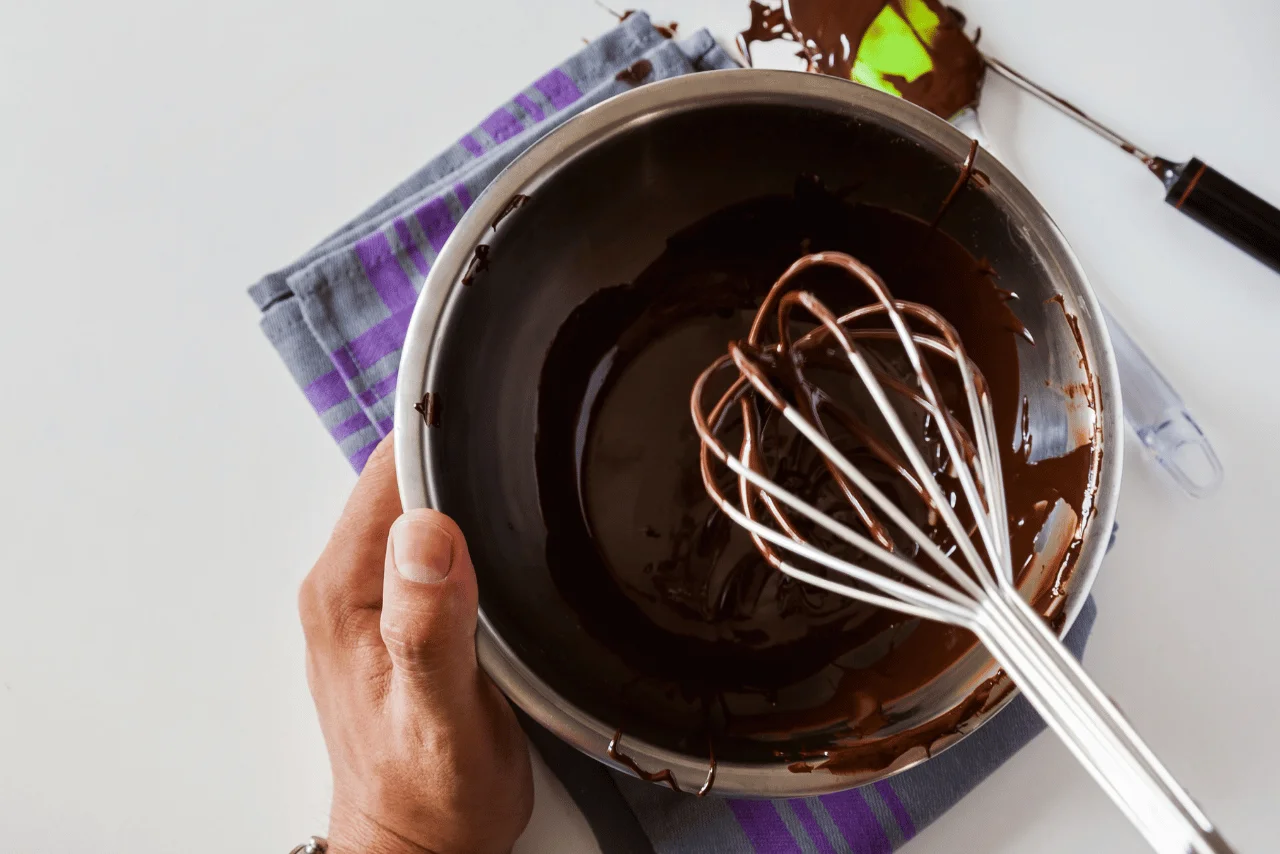Çikolata temperleme aşamasında eritilmiş çikolata ve çırpıcı